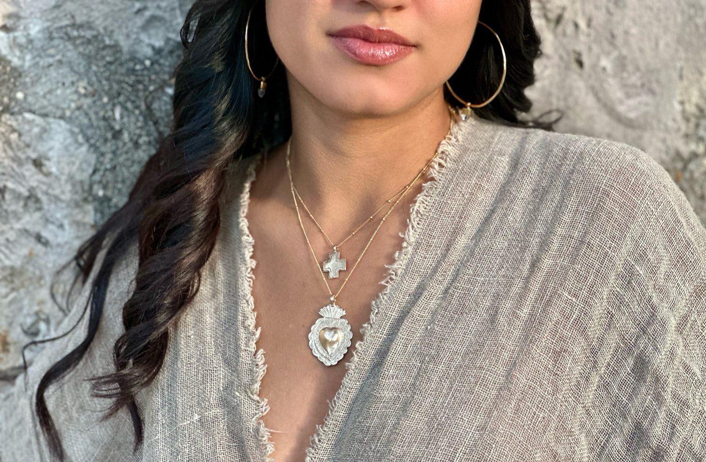 Close-up of silver sacred heart pendant on model