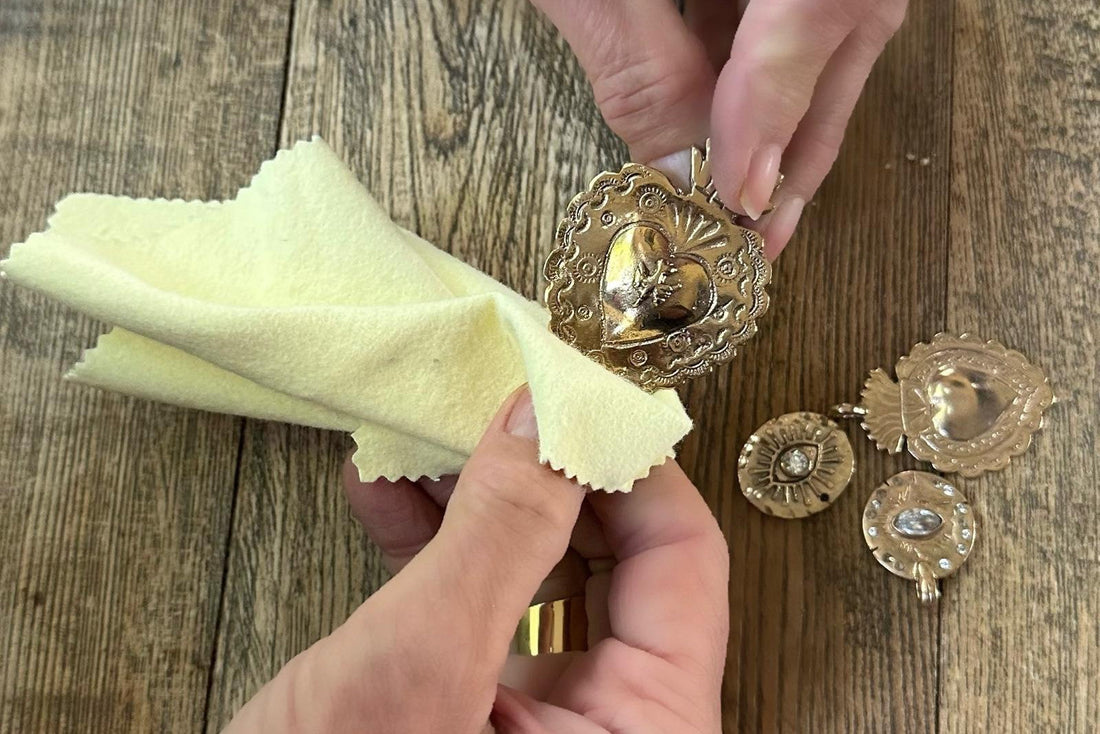 hands cleaning pendants with a jewelry cloth