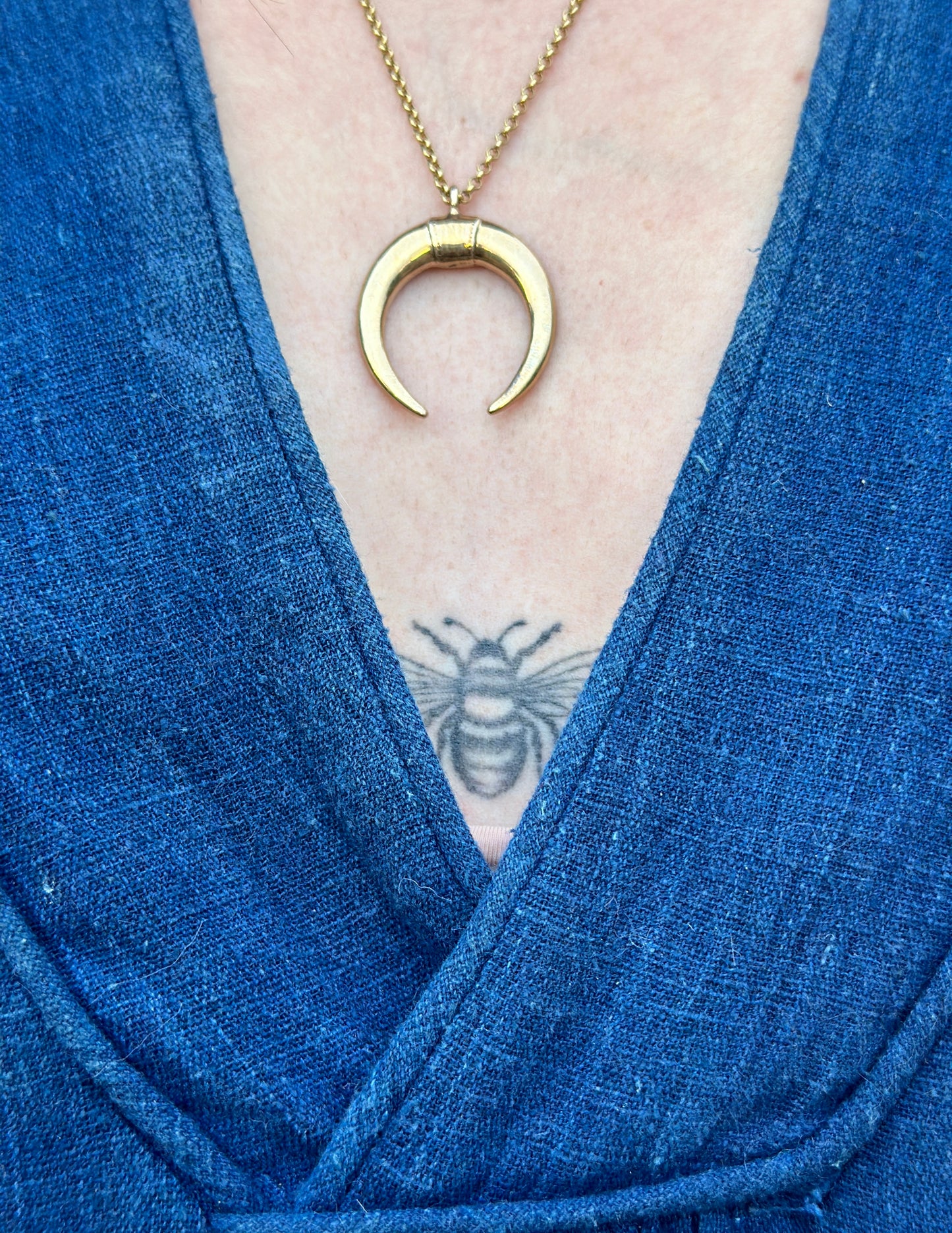 Gold statement necklace featuring symbolic double horns