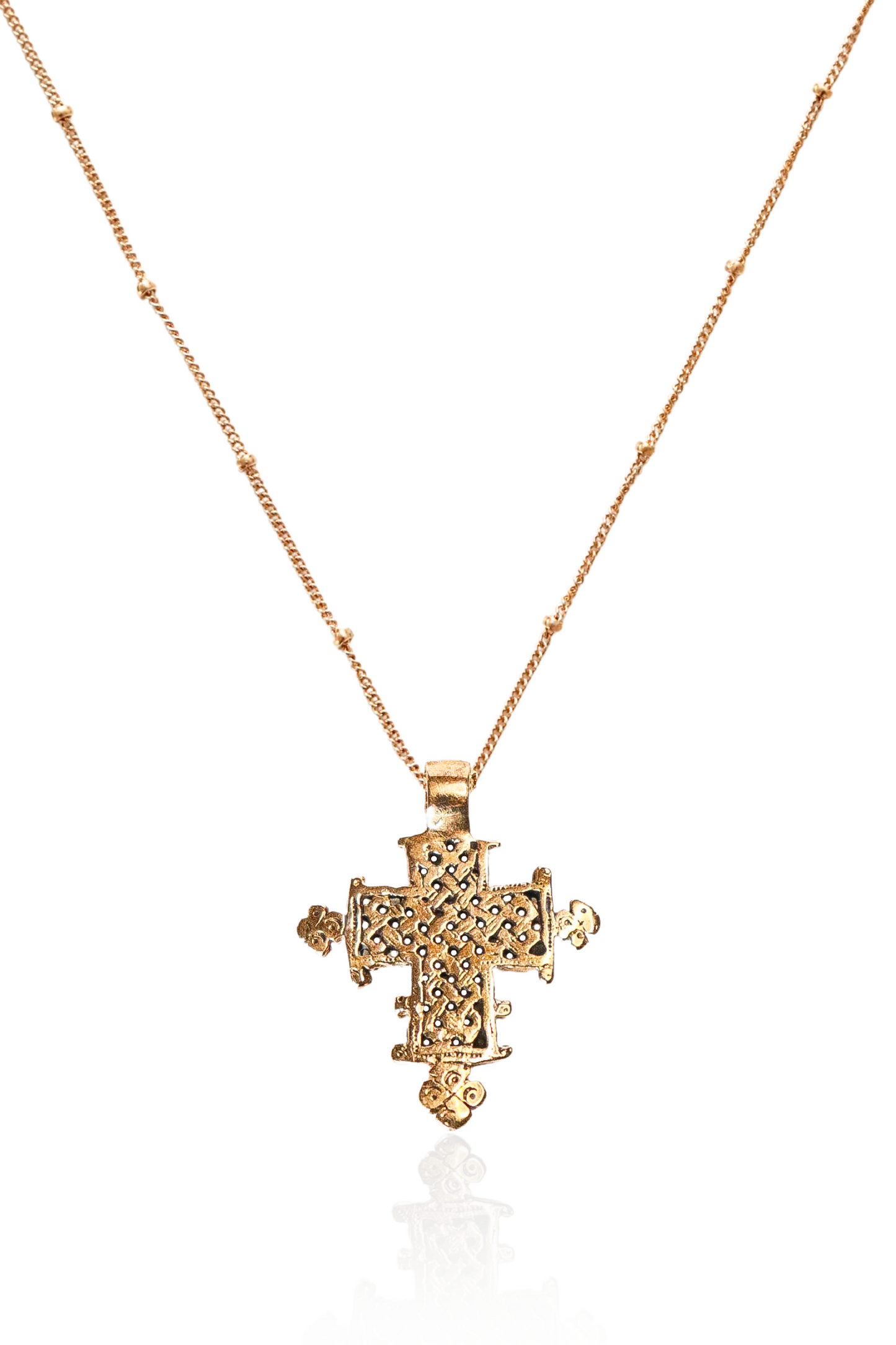 Close-up of bronze lattice Ethiopian cross on gold chain