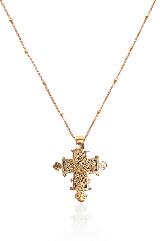 Close-up of bronze lattice Ethiopian cross on gold chain