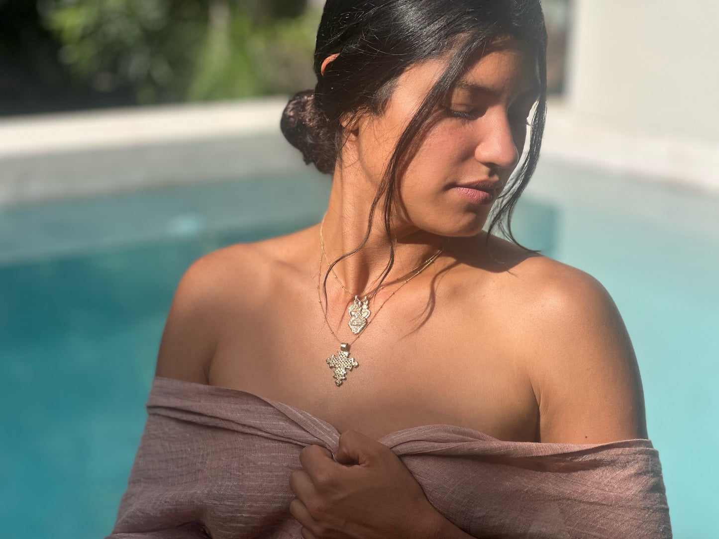 Boho gold necklace with detailed Ethiopian cross on model