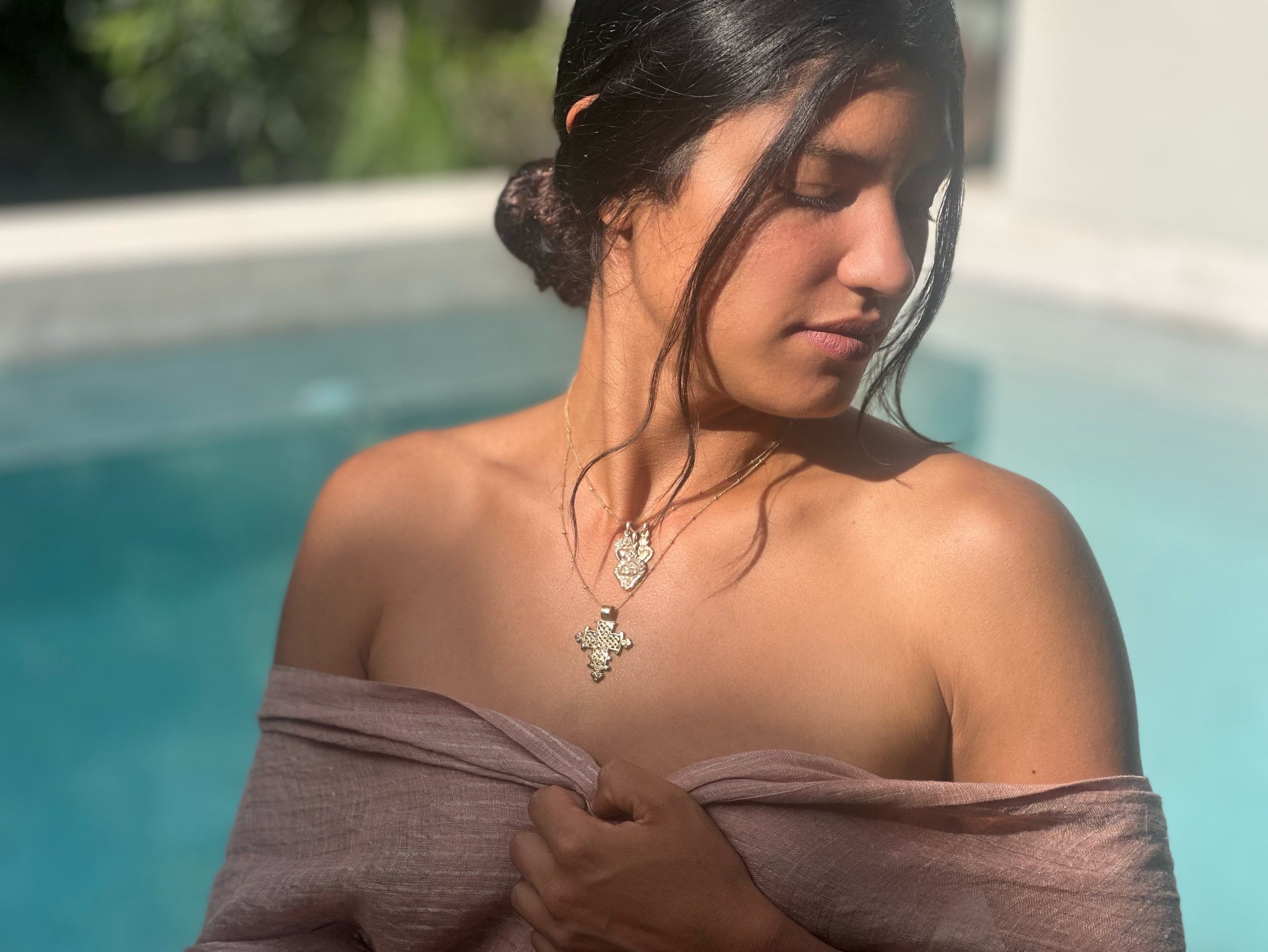 Boho gold necklace with detailed Ethiopian cross on model