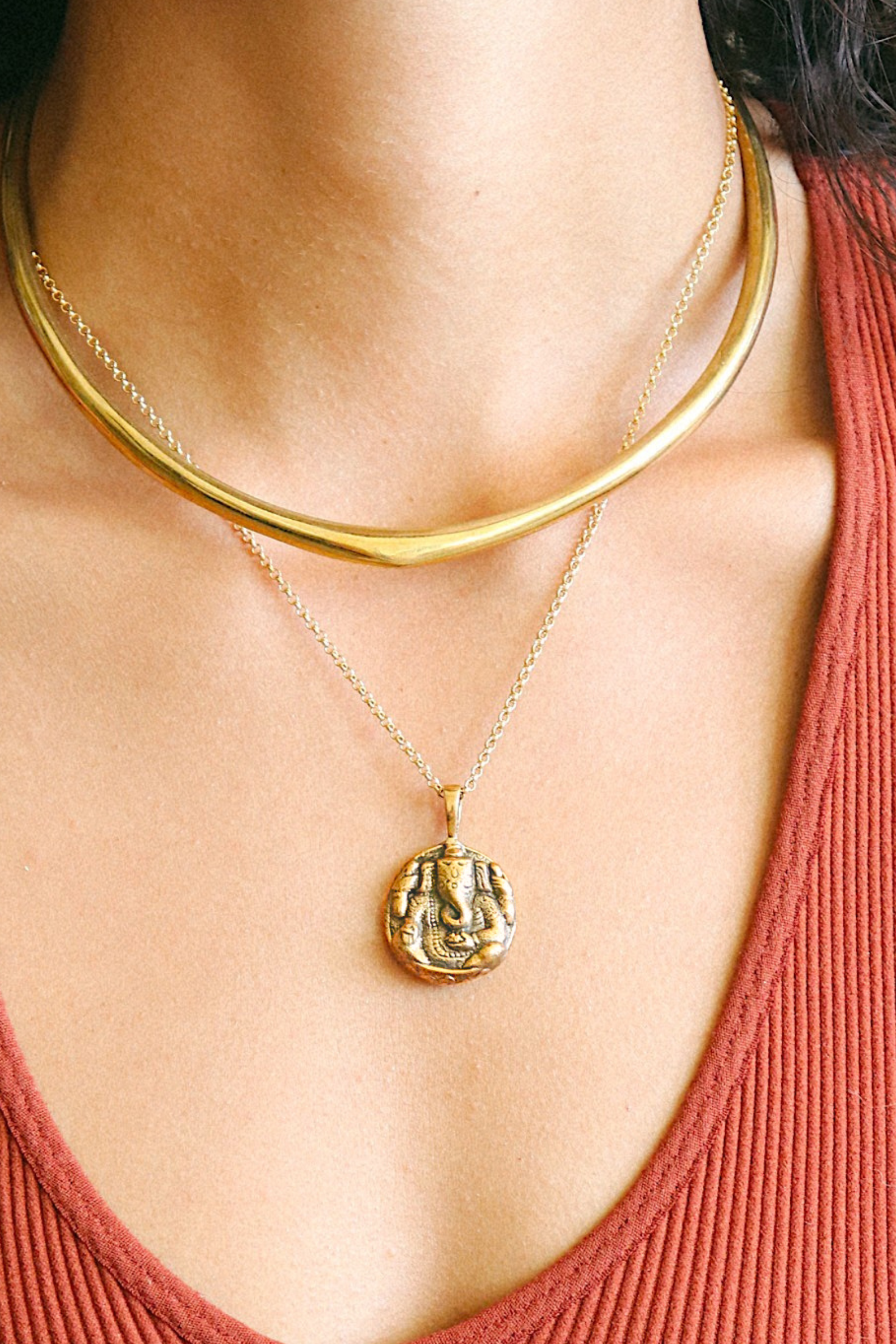 Model wearing gold Ganesha Necklace layered with other boho necklaces