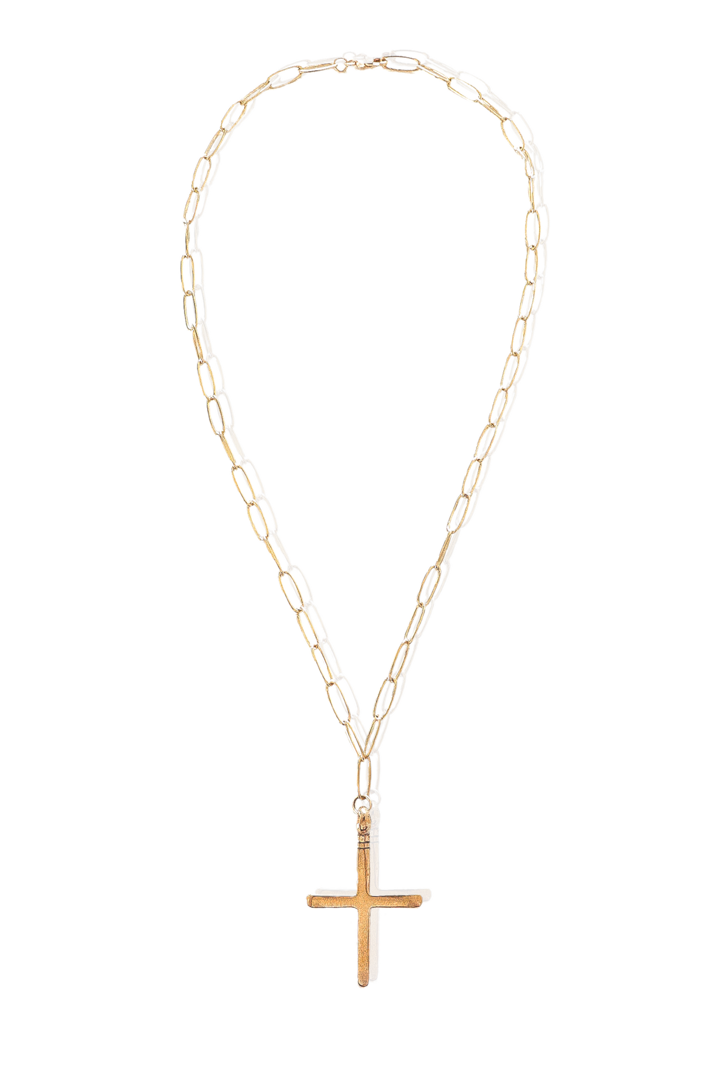 Simple gold cross necklace displayed on neutral background