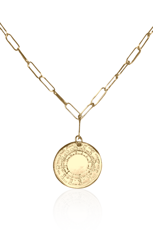 Close-up of engraved African coin necklace in gold