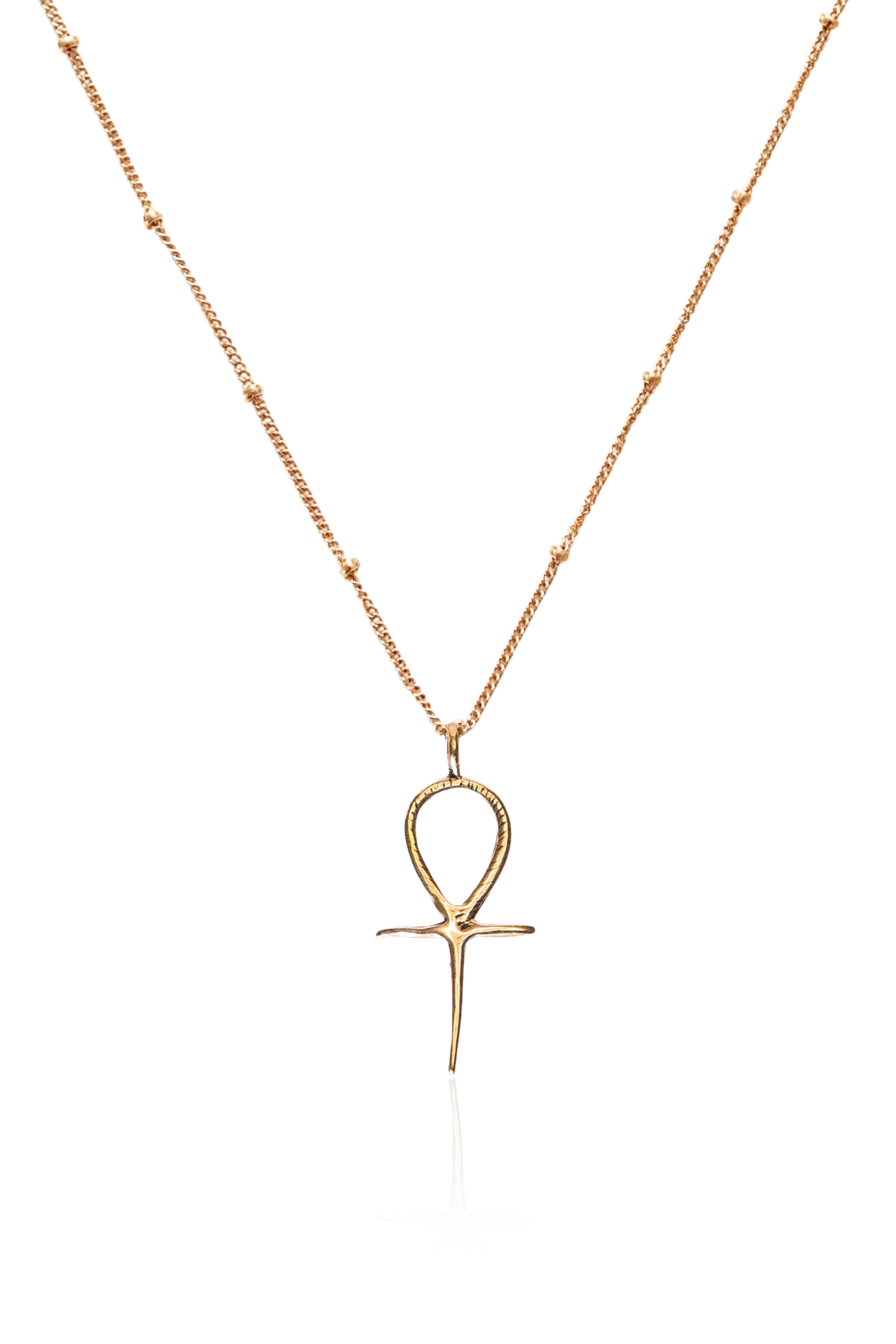 Close-up of detailed bronze Ankh pendant on gold chain