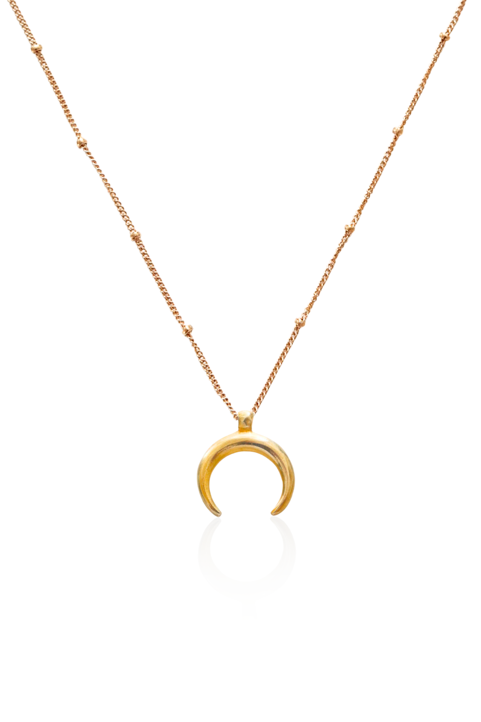 Close-up of gold moon pendant hanging downward