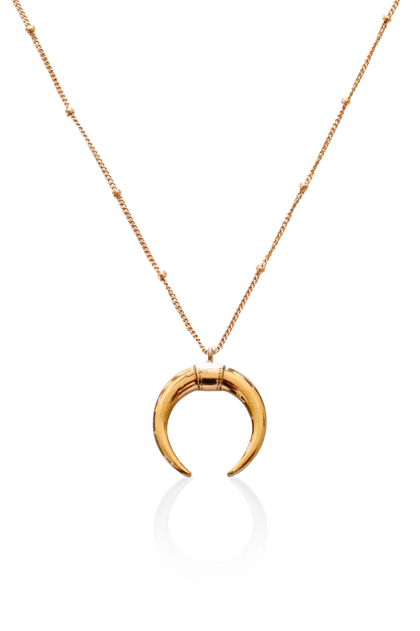 Close-up of gold double horn pendant on satellite chain