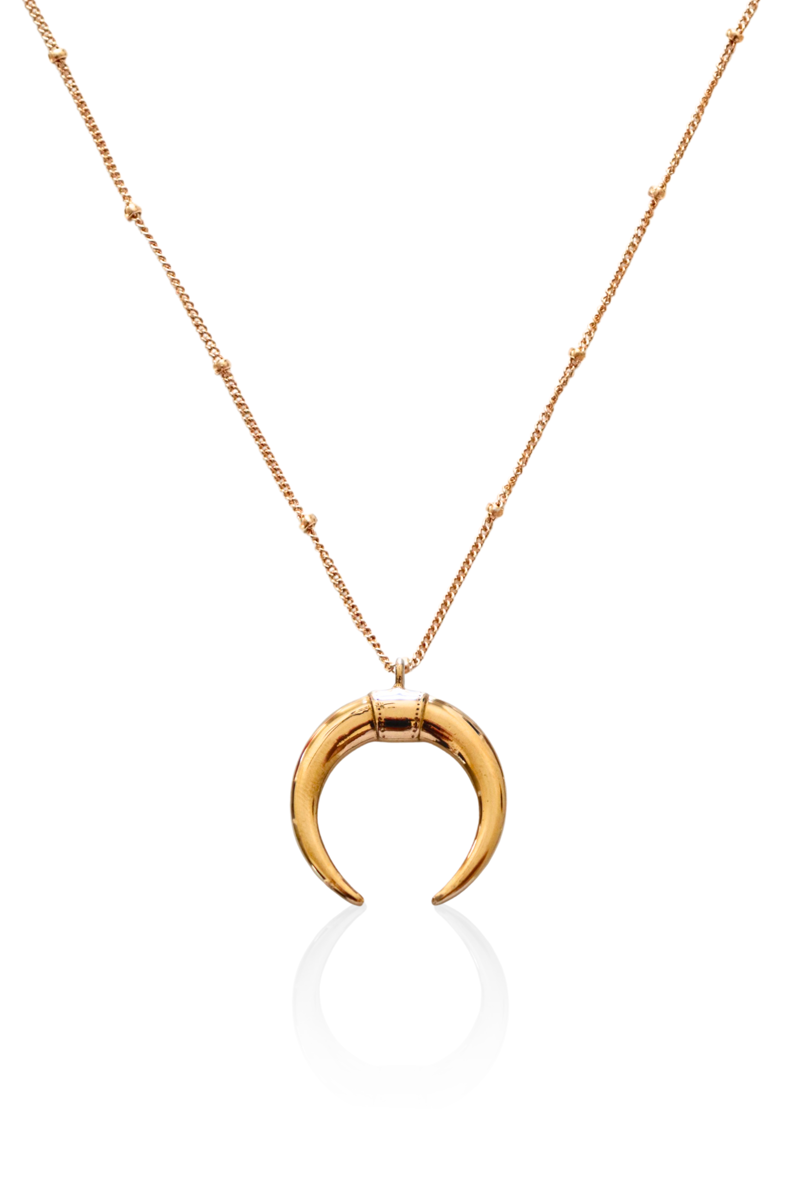 Close-up of gold double horn pendant on satellite chain