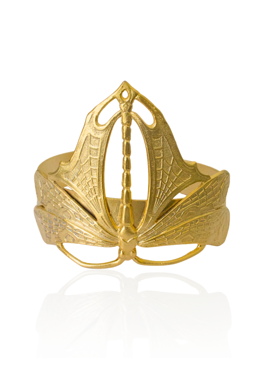 Gold dragonfly cuff bracelet with detailed engraved wings on an adjustable open band.