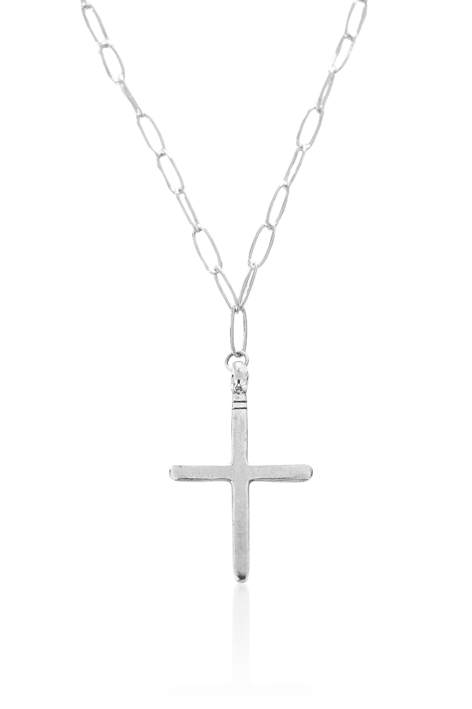 Close-up of silver cross pendant on sterling silver link chain