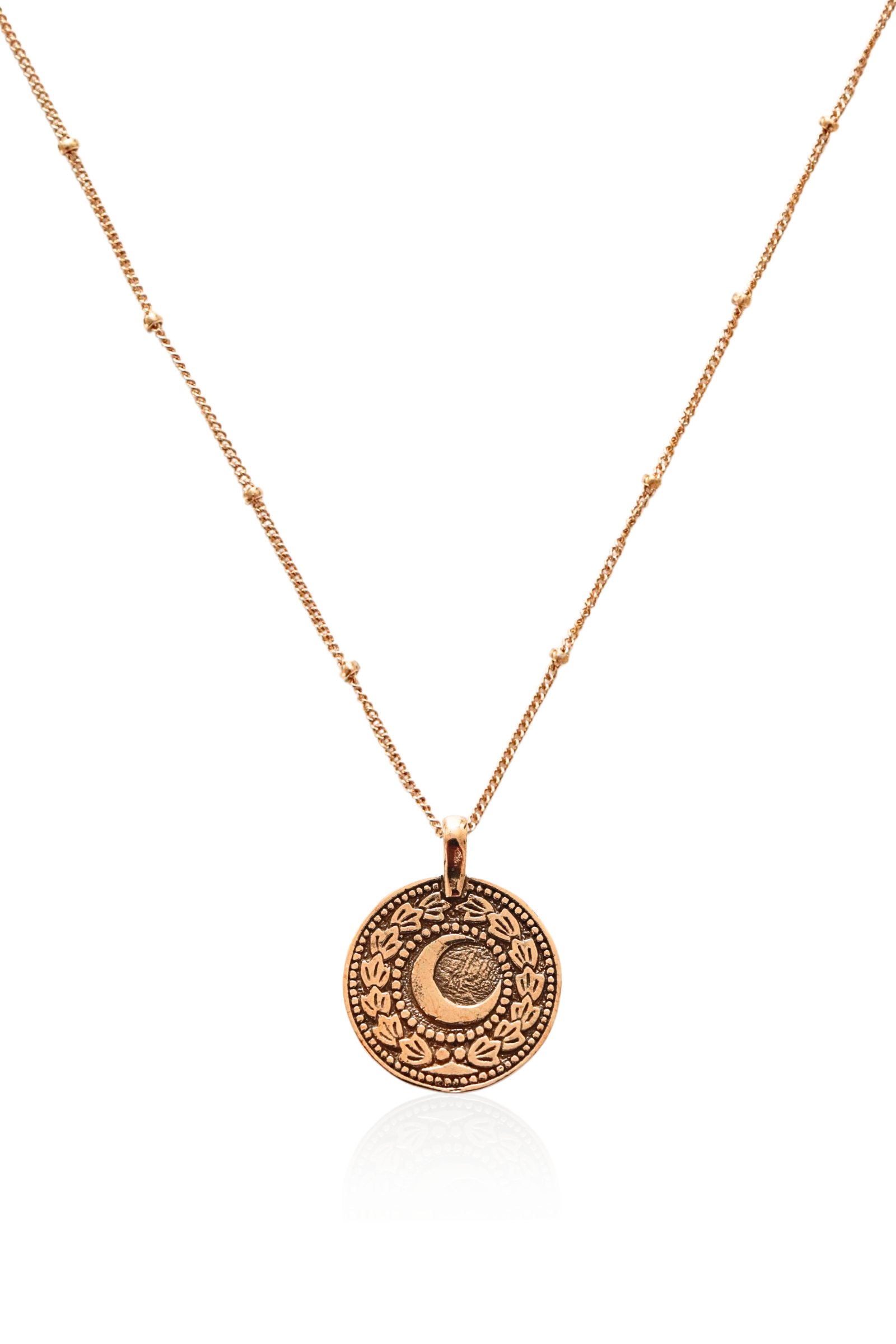 Close-up of bronze coin pendant featuring sun and moon symbols