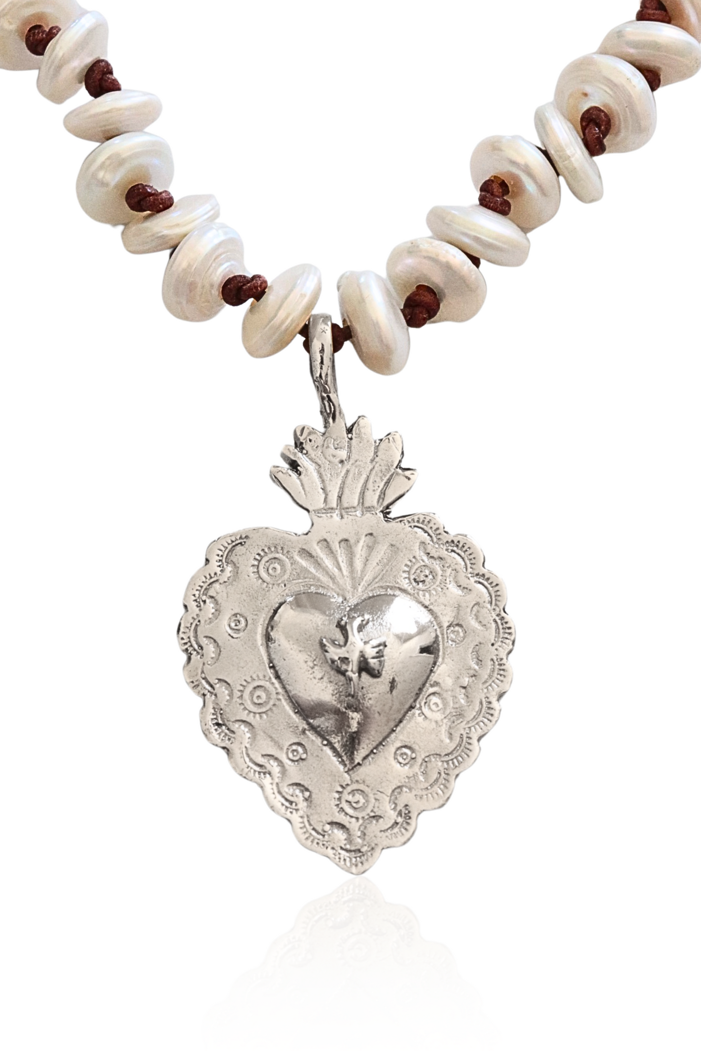 Close-up of sterling silver Sacred Heart on pearl and leather strand