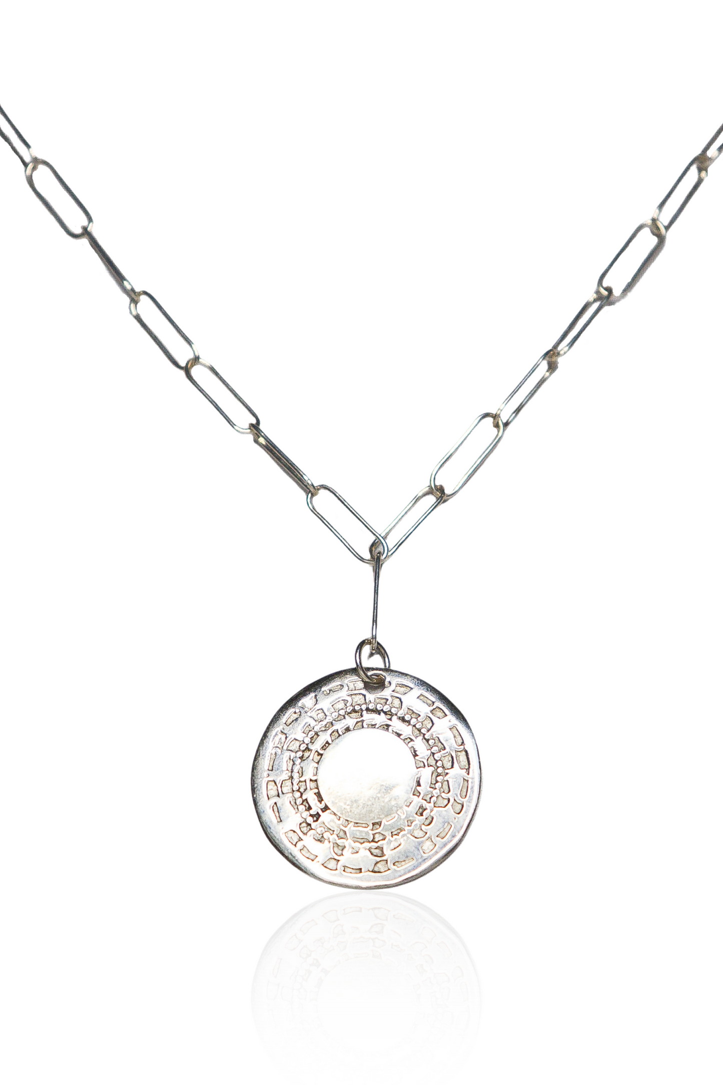 Close-up of silver engraved coin necklace