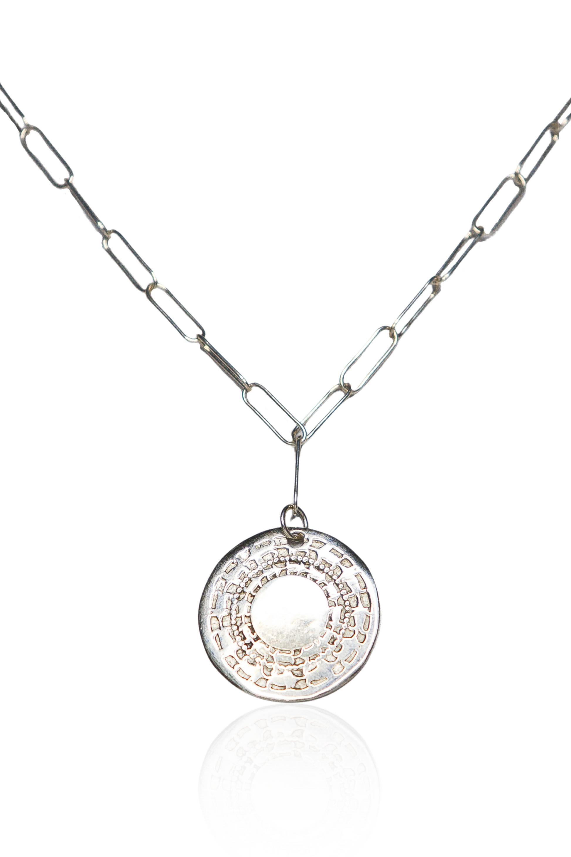 Close-up of silver engraved coin necklace