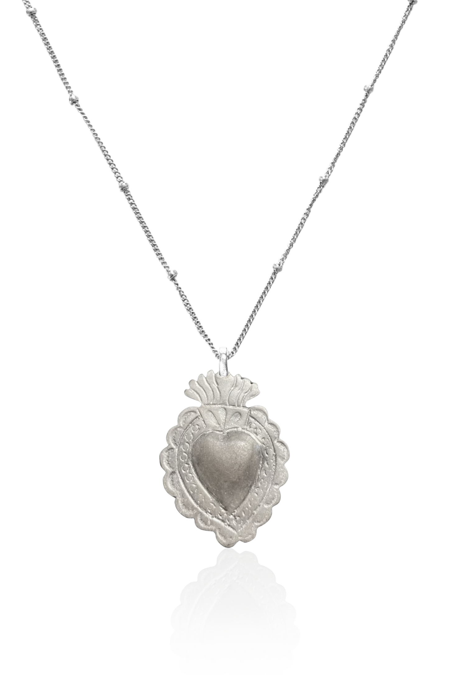 Close-up of silver sacred heart pendant on chain