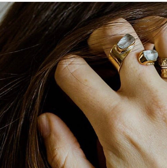 Adjustable gold crystal quartz ring styled on model’s finger
