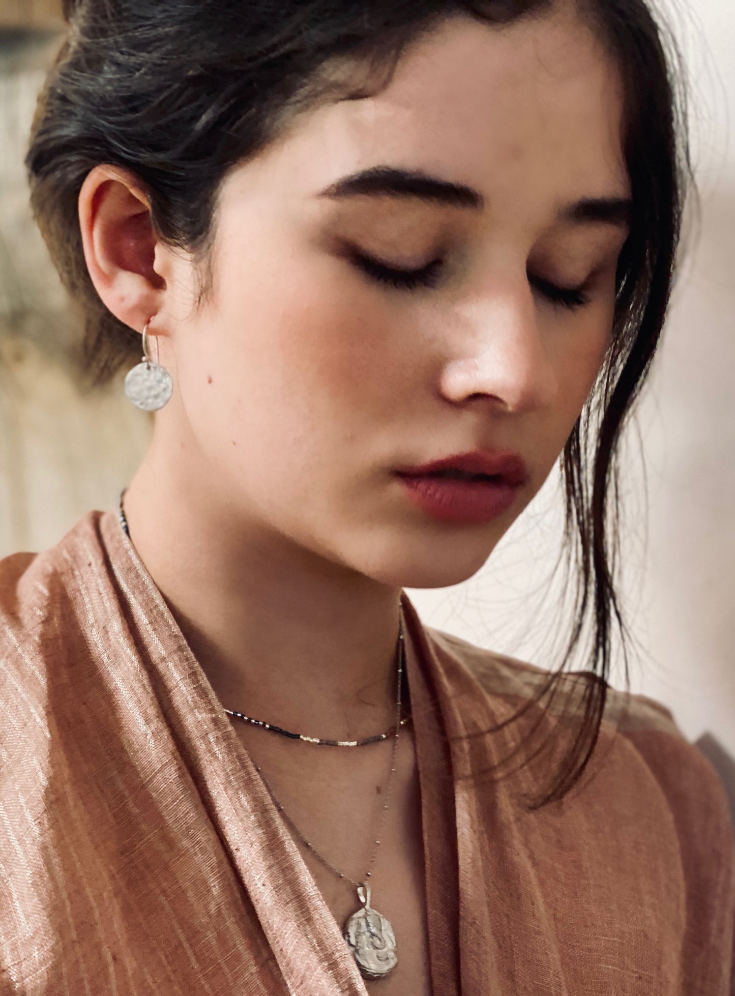 Model wearing sterling silver Ganesha Necklace layered with minimalist chains