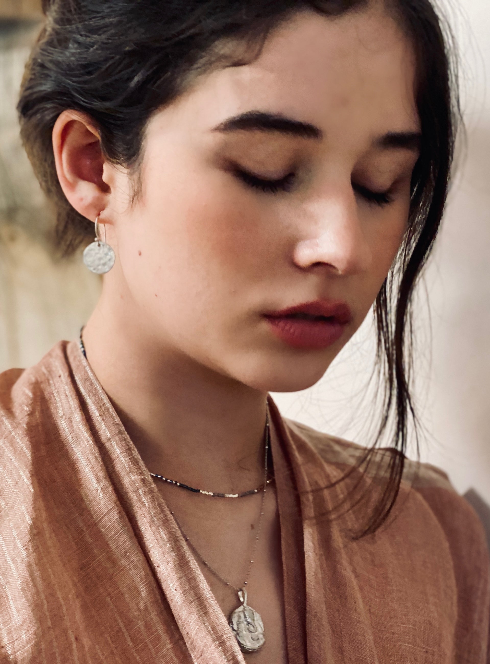 Model wearing sterling silver Ganesha Necklace layered with minimalist chains