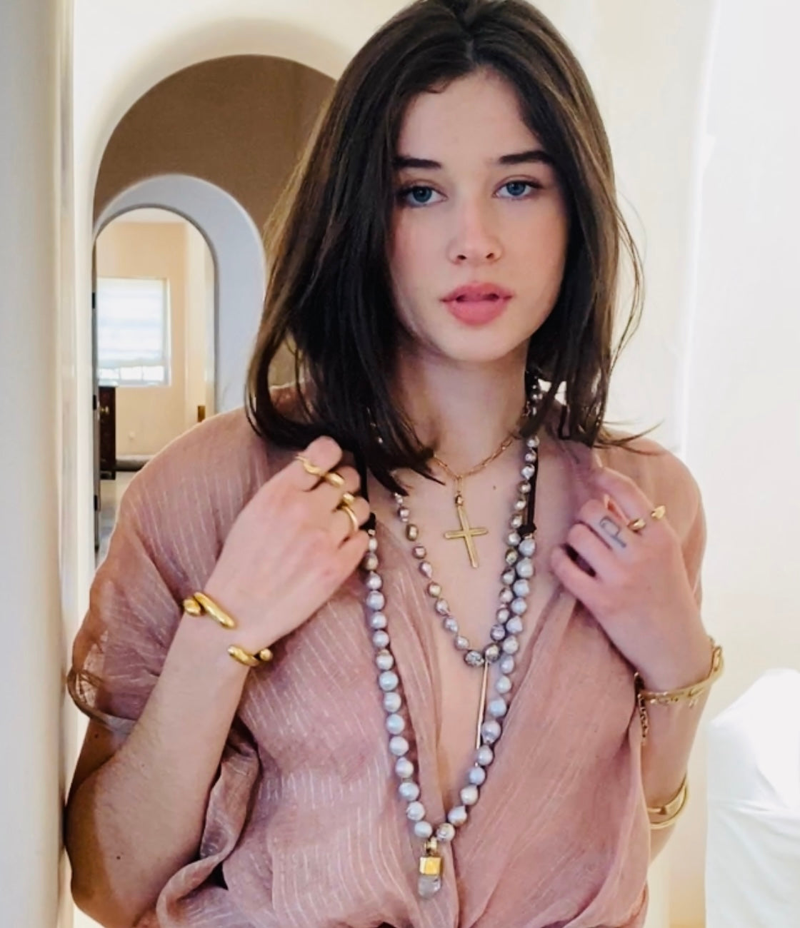 Model wearing Latin cross necklace with other boho necklaces