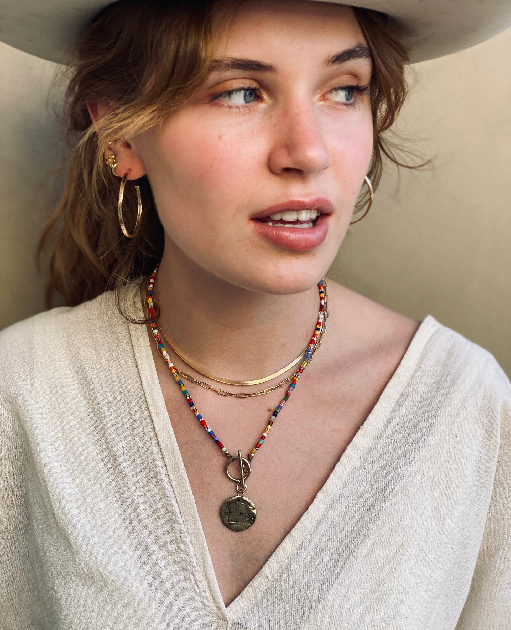 Hand-hammered gold hoop earrings on model